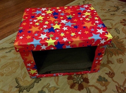 diy-cardboard-cat-bed DIY Cardboard cat bed covered in red fabric with different colored stars.