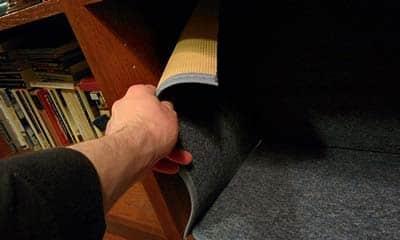 手工將地毯固定在書架內側