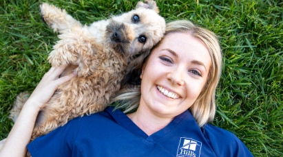 希爾思寵物專業醫師與狗狗一起躺在草地上